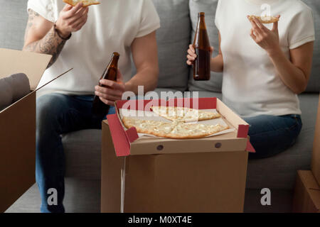 Couple eating pizza celebrating housewarming party on moving day Stock Photo