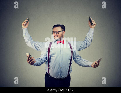 Chunky young man in formal clothing having four arms and using smartphones being multitasking. Stock Photo