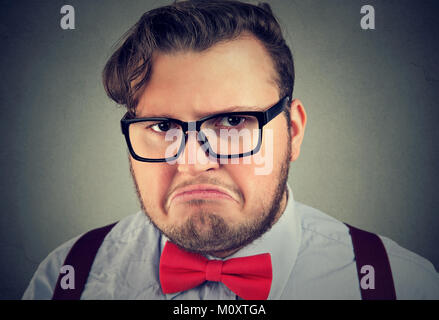 Portrait of chunky man in eyeglasses looking offended and gloomy posing at camera. Stock Photo