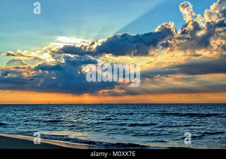 Beach, summer, relaxation and resting concept-picturesque and beautiful sunset on the sea with sunrays and dark clouds above the north sea. Stock Photo
