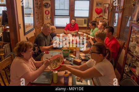 Extended family of three generations having dinner together at a long table. St Paul Minnesota MN USA Stock Photo