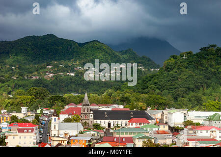 Sunlight warms the town of Roseau under stormy skies, Dominica, Leeward Islands, West Indies Stock Photo