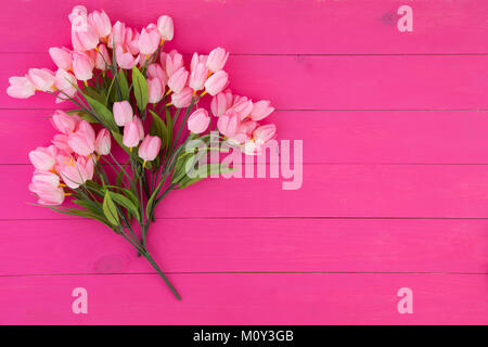 Bouquet of fresh pink flowers on a matching vibrant pink wood background with copy space for your greeting or wishes to a loved one Stock Photo