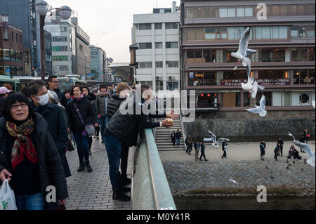 23.12.2017, Kyoto, Japan, Asia - Pedestrians are seen crossing the Shijo Bridge that spans over the Kamo River in central Kyoto. Stock Photo