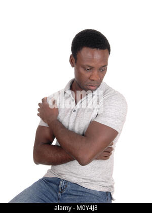 A young African American man sitting and looking down very sad and depressed, isolated for white background Stock Photo