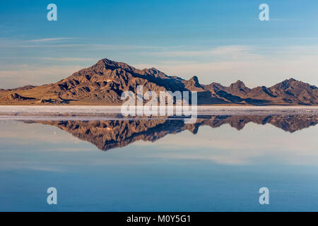 Silver Island Range reflecting in salty water at the Bonneville Salt Flats, which is BLM land west of the Great Salt Lake, Utah, USA Stock Photo