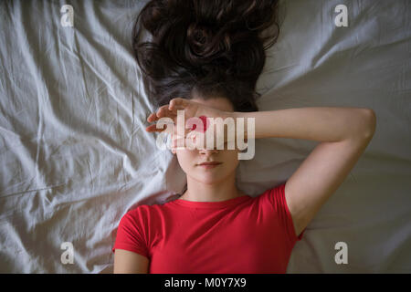 Attractive brunette young woman with drawing heart on hands in the bed Stock Photo