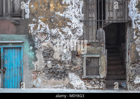 Decrepit colonial building with blue door and staircase in Havana, Cuba Stock Photo