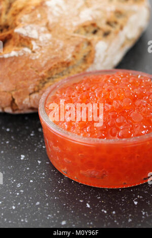 Red caviar in a glass bowl and fresh baked bread. Traditiona Stock Photo