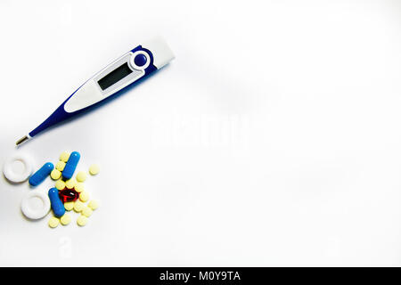 yellow, blue, red pills and the thermometer , medicine isolated on white background. Stock Photo