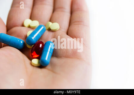 yellow, blue, red pills  medicine on a hand Stock Photo