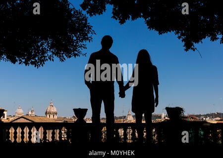 Silhouette couple holding hands overlooking the city of Rome,Italy Stock Photo