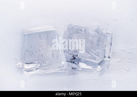 Two ice cubes on wet white surface Stock Photo