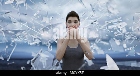 Shards of glass surrounding woman covering mouth with hands Stock Photo