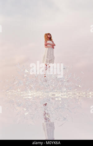 Woman hovering in shards of glass Stock Photo