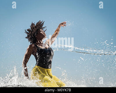 Water spraying on black woman dancing Stock Photo