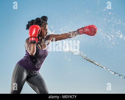 Water spraying on black woman boxing Stock Photo