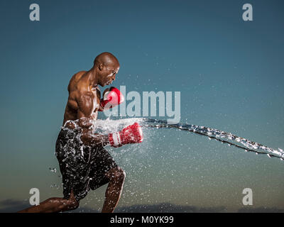 Water splashing on black boxer punching Stock Photo