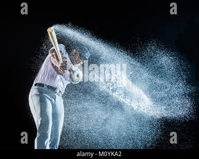 Water splashing from swinging bat of black baseball player Stock Photo