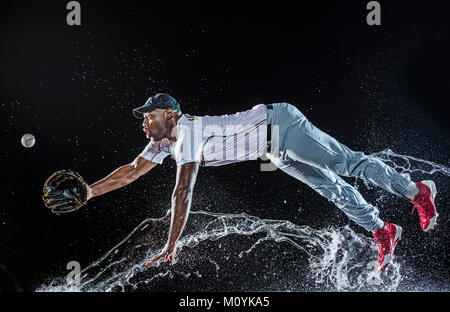 Water splashing on diving black baseball player Stock Photo