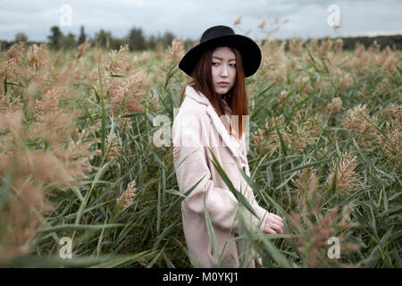 Asian woman standing in field Stock Photo