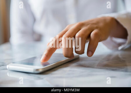Finger of African American woman using cell phone Stock Photo