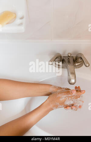 African American woman washing hands with soap Stock Photo