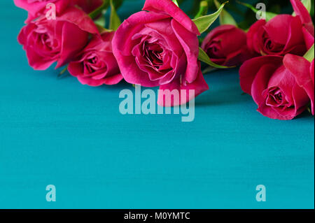 Red roses on blue wooden background. Valentines day background with red roses. Wedding background. Top view with copy space. Mother's Day, Happy birthday , Women's Day. Stock Photo