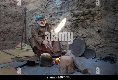 Nizwa, Oman, December 15th, 2016: Omani man roasting arabic coffee in a traditional house Stock Photo