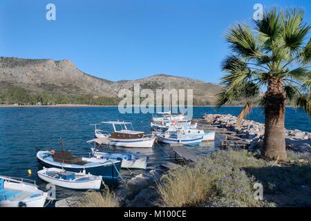 Fishing boats moored on a jetty at one end of Karathona Bay in the Gulf of Argolis, near Nafplio, Argolida, Greece, July. Stock Photo