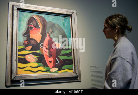 Hamburg, Germany. 25th Jan, 2018. Hamburg, Germany, 25 January 2018. A woman looking at the 1938 painting 'Masken' ('Masks') in the exhibition 'Karl Schmidt-Rottluff: expressive, magical, foreign' in the Bucerius Kunstforum in Hamburg, Germany, 25 January 2018. The works by the artist from the 'Die Bruecke' group of artists will be on display in Hamburg between 27 January and 21 March 2018. ATTENTION EDITORS: EDITORIAL USE ONLY IN CONNECTION WITH CURRENT REPORTING/MANDATORY CREDITS. Credit: Axel Heimken/dpa/Alamy Live News Stock Photo