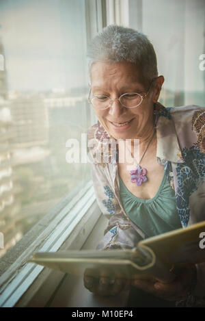 Elderly woman browsing old photographs at a village history open day ...
