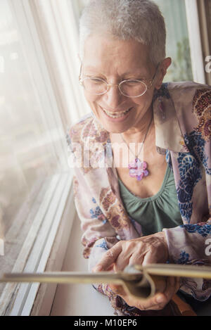 Elderly woman browsing old photographs at a village history open day ...