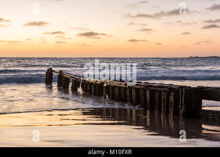 A Victor Harbor beach sunrise over the erosion groynes in South ...