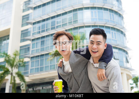 Best friends. Two guys hugging and walking in the city. Stock Photo