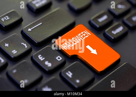 Halloween written on a computer orange keyboard key Stock Photo
