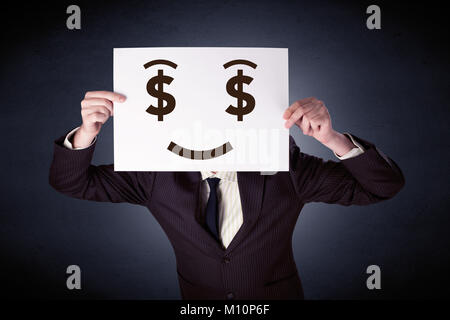 Young casual businessman hiding behind a greedy face drawing on cardboard Stock Photo