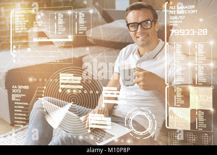 Cheerful man using his laptop at home Stock Photo