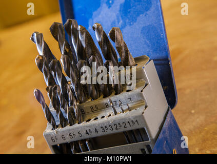 A box of drill bits on a work bench, covered in wood dust,sawdust,shavings, Stock Photo