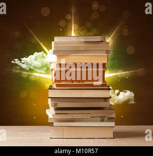 Magical books with ray of lights and colorful clouds on vintage background Stock Photo