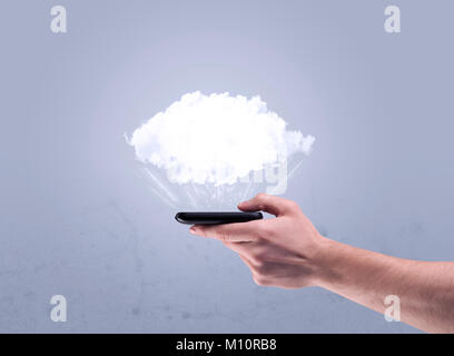 A male hand holding a mobile phone from profile view with an empty white cloud above the device for sales concept Stock Photo
