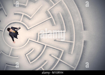 Confused business man trapped in a circular maze Stock Photo