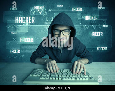 A young handsome nerd hacking internet web sites while working on computer keyboard, with digital background illustration of numbers and letters conce Stock Photo