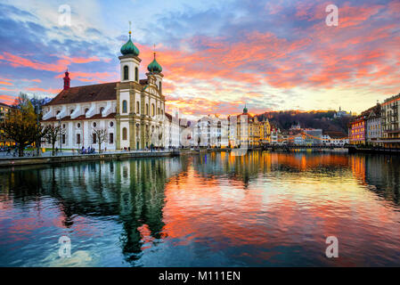 Dramatic sunset reflecting in river over historical old town of Lucerne, Switzerland Stock Photo