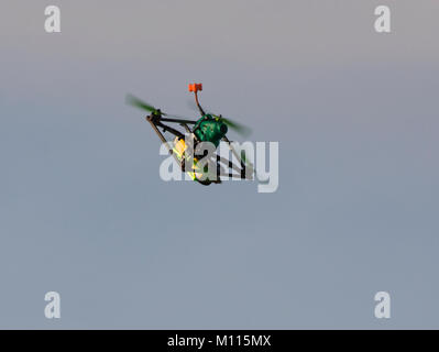 Small drone in flight against blue sky Stock Photo