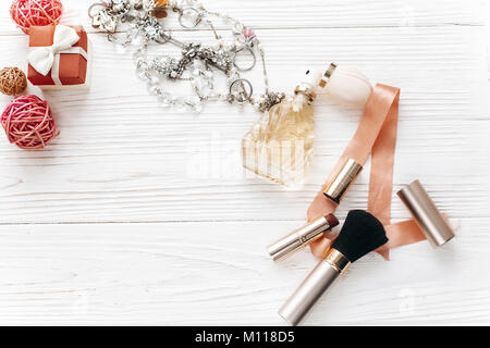 luxury expensive jewelry and make up essentials and perfume flat lay on white rustic wooden table with space for text.  fashion blogger. modern woman  Stock Photo