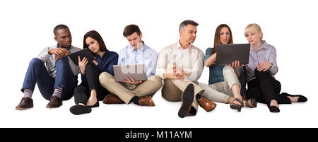Business Team Using Electronic Devices Against White Background Stock Photo