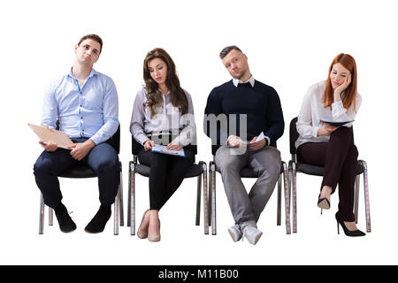 Bored Business People Sitting In Row Waiting For Job Interview Against White Background Stock Photo