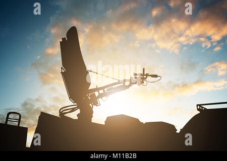 Silhouette Of Satellite Dish Antenna On Top Of TV Van Against Sky Stock Photo