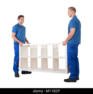 Two Male Professional Movers Placing The White Empty Shelf In New Home Against White Background Stock Photo